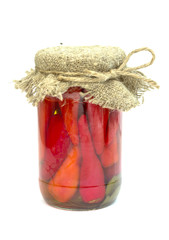 canned red peppers in a glass jar isolated on a white background