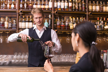 Bartender serving Wine to Customer at counter, Bartender enjoy to serving Wine for Customer, People Lifestyle Concept.