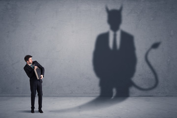 Fototapeta premium Business man looking at his own devil demon shadow concept
