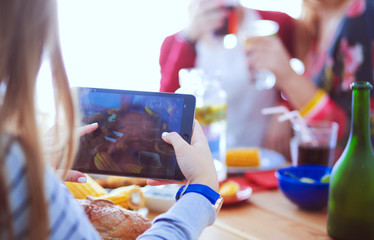 Top view of group of people having dinner together while sitting at wooden table. Food on the table. People eat fast food.