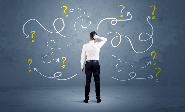 Unsure businessman with question marks - Powered by Adobe
