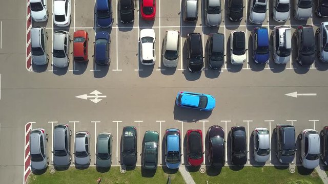 AERIAL TOP DOWN, TIMELAPSE: Bad driver incapable to park a car on parking space in big crowded parking lot. Female having problems, unable to park a car in parking spot. Parking fail on parkspace