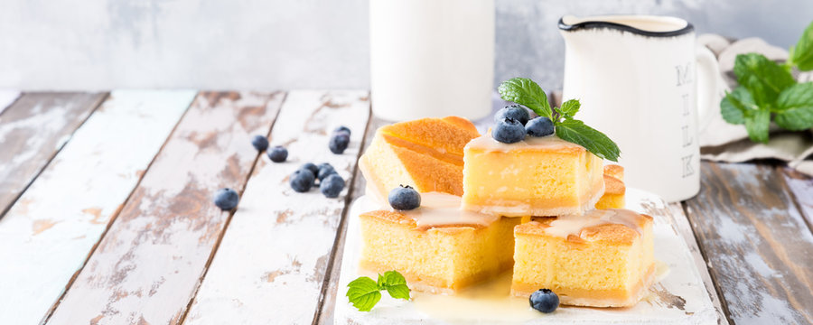 Healthy dessert. Homemade pudding cake with custard cream and blueberries. Sweet gluten free food. Banner with copy space.