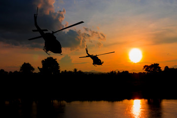 Fototapeta na wymiar soldier silhouette in rappelling climb down from helicopter on sunset with copy space add text
