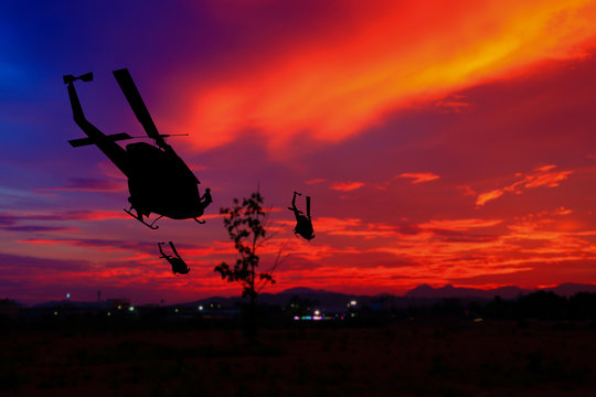 soldier silhouette in rappelling climb down from helicopter on sunset, Concept stop warfare with copy space add text