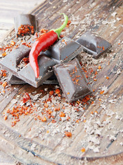 pieces of chocolate with chili peppers on a wooden table