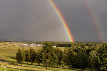 Karlovy Vary airport after storm under cloudy sky with rainbow