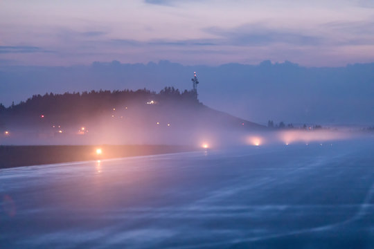 Empty runway at airport during a foggy evening