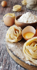 Obraz na płótnie Canvas Uncooked pasta with flour on the table, selective focus