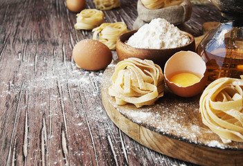 Uncooked pasta with flour on the table, selective focus