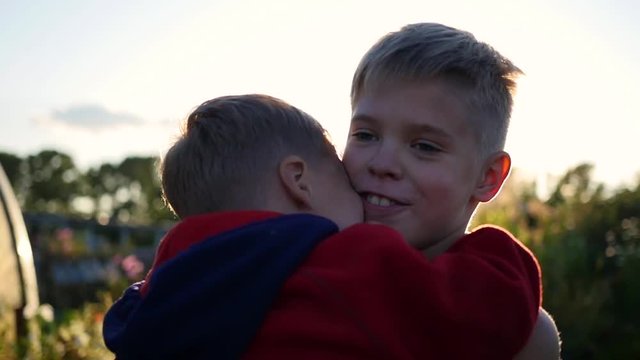 Little baby tenderly hugging and kissing his older brother. boy hugging his younger brother