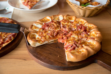 Pizza is delicious on the wooden table.