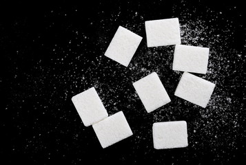 White sugar cubes isolated on black background and texture