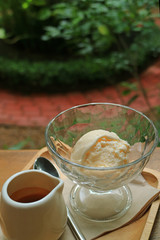 Affogato served on outdoor coffee table, vertical photo, blurred background 