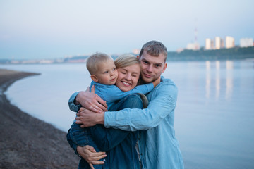 Fototapeta na wymiar happy family hugging river shore evening