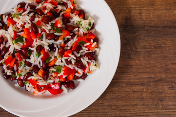 rice with red beans and vegetables on wooden table. with copy space. top view.