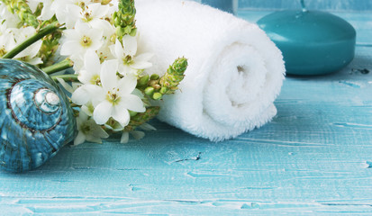White flowers lying on and candle Spa set