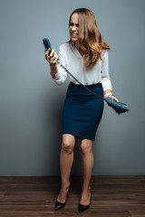 Cheerless stressed woman looking at the phone receiver