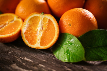 Orange, half of orange, orange lobule on the wooden table.