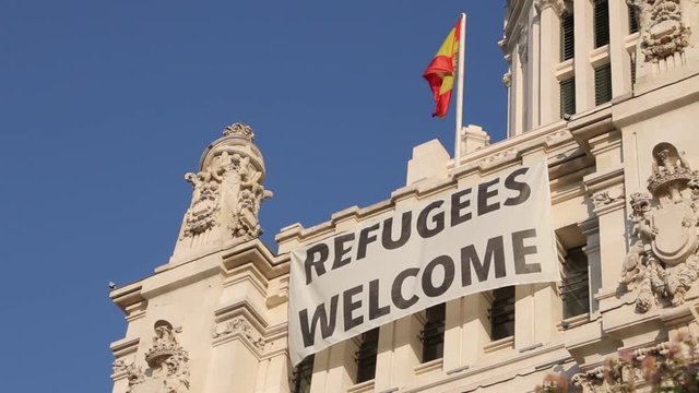 Refugee welcome flag on the facade of Palacio de comunicaciones in Madrid, Plaza Cibeles, Spain