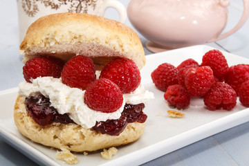 english scone with whipped cream and fresh raspberry