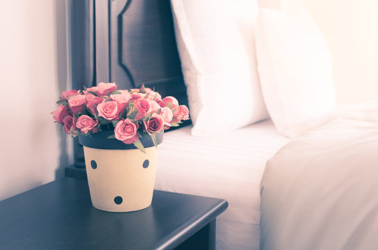 Flower vase on night table in bedroom, vintage style image.