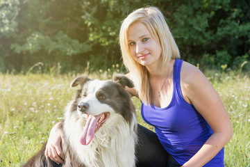 Portrait of smiling young woman with her Border Collie outside
