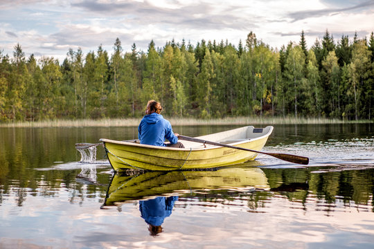 Finnland, leben im M&ouml;kki, auf einer Insel die nur mit dem Ruderboot zu erreichen ist. Der n&auml;chste Ort Juvola ist 1 km entfernt. Region Linnansaari Nationalpark, Mann rudert &uuml;ber den See