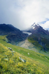 Kazbek top over the green grass