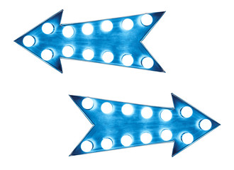 Two blue vintage bright and colorful illuminated metallic display arrow signs with light bulbs against a seamless white background and copy space in the middle of the arrow