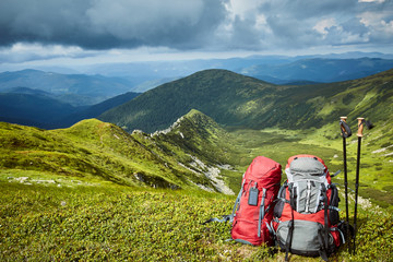 Backpacks in the mountains overlooking the mountains on the green grass.
