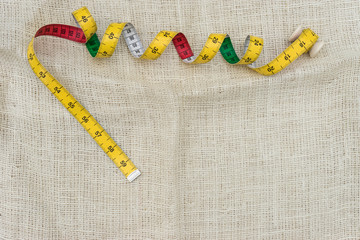 yellow measure tape on sack background. accessory for tailor. copy space for input text