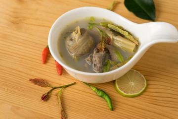 spicy chicken soup with tamarind leaf and herb in bowl. Thai food name 
