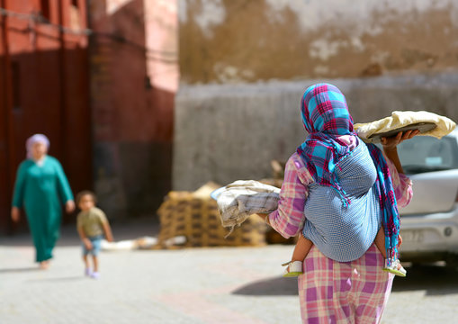 Moroccan woman with a child behind her, sells bread on the streets of the city