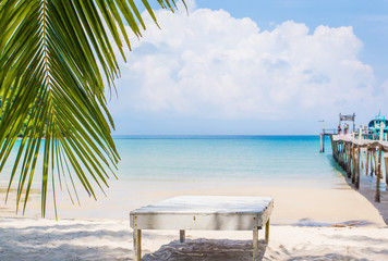 Palm leaf and tropical beach in Holiday