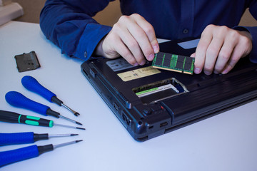 close up picture of hands and broken notebook, men repair laptop