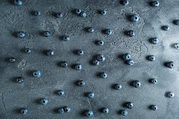 Pattern made of blueberries on dark background. Food background. Flat lay, top view