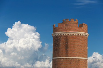 Brick tower on blue sky background.
