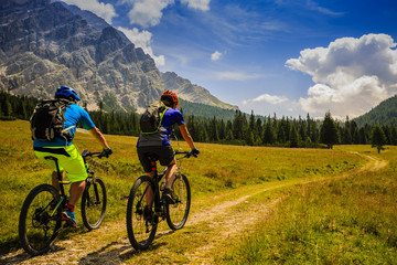 Mountain cycling couple with bikes on track, Cortina d'Ampezzo, Dolomites, Italy