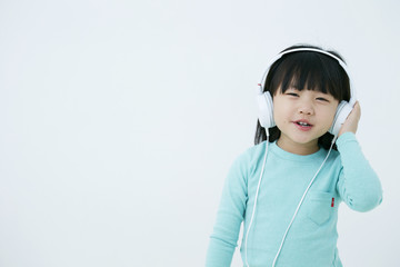 Little Korean girl listening to music 