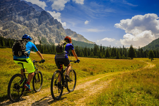 Mountain cycling couple with bikes on track, Cortina d'Ampezzo, Dolomites, Italy