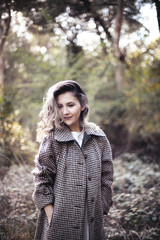 Young blond female portrait outdoors in Tirana Grand Park. Autumn look: beige wool coat.