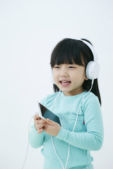Little Korean girl listening to music 