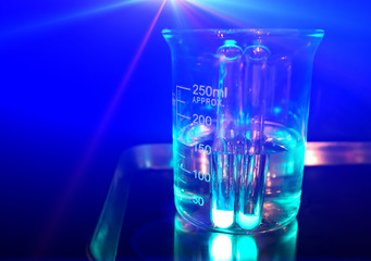 Glass flask filled with chemical solution. Chemical glass with transparent liquid.