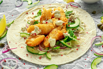 Fresh Fish Tortilla with cucumber, red onion, Capers, lemon, salad leaves and tartare sauce. Healthy Food