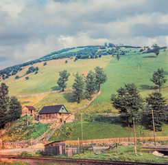 Naklejka premium House under the mountain near the railway