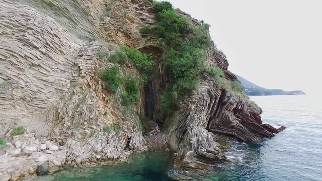 Woman in the cave. Footage. Top view of the woman in the cave by the sea
