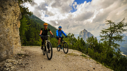 Fototapeta na wymiar Mountain cycling couple with bikes on track, Cortina d'Ampezzo, Dolomites, Italy