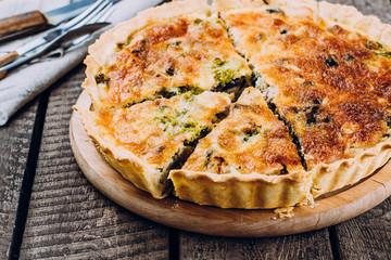 Quiche Lorraine with chicken and vegetables on rustic dark table background. Pie with mushrooms,...