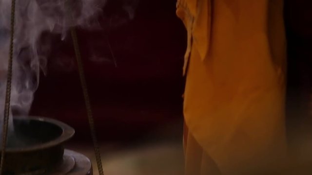 a monk holds incense in a buddhist temple